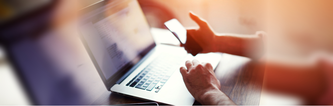 man making reservation using mobile and laptop